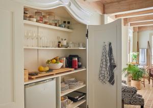 开普敦Villa del Mar - "Luxurious en-suite bedroom with lounge and stunning sea view balcony in Bantry Bay"的厨房配有开放式储藏室，里面有食物