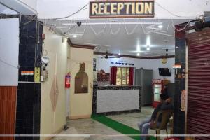 a person sitting in a chair in a room at HOTEL SAVITRI Near Shree Baba Baidyanath Temple in Deoghar
