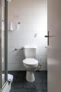 y baño con aseo blanco en una cabina. en Hotel Regina en Darmstadt