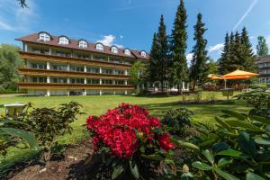 een groot gebouw met rode bloemen ervoor bij Parkhotel in Bad Waldsee