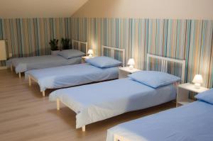 a room with three beds with blue pillows at Smart Stay Hostel Gdynia in Gdynia