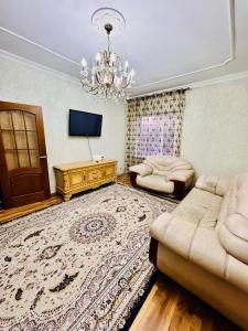 a living room with two couches and a chandelier at Cottage Лома city center 7 to 2 floor in Taldykorgan