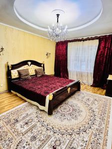 a bedroom with a bed and a chandelier at Cottage Лома city center 7 to 2 floor in Taldykorgan