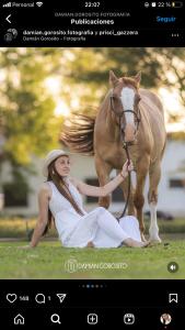 a woman sitting on the ground next to a horse at Santa Regina in Progresso