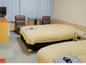 a room with two beds and a table and a chair at Ikebukuro Royal Hotel in Tokyo