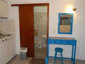 a small bathroom with a blue table and a stool at Dimitris studios in Kokkari