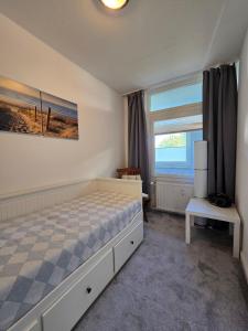 a bedroom with a bed and a large window at Vier Jahreszeiten 5-2 in Großenbrode-Kai