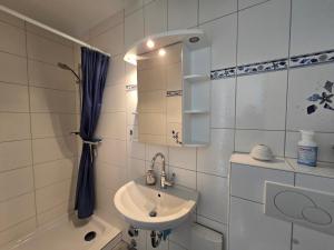 a bathroom with a sink and a mirror and a tub at Vier Jahreszeiten 5-2 in Großenbrode-Kai