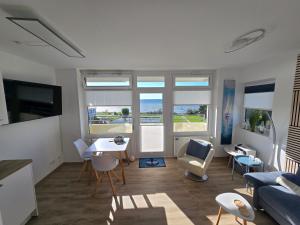 a living room with a table and chairs at Vier Jahreszeiten "Strandglück" im Haus 2 Wohnung 45 in Großenbrode-Kai