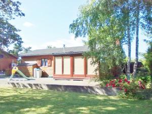 uma casa com um parque infantil em frente em chalet Imme em Resteigne