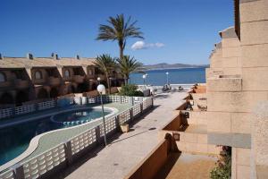un complexe avec une piscine à côté de l'océan dans l'établissement Torre Luquillo, à La Manga del Mar Meno