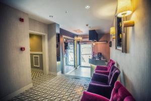 ein Wartezimmer mit lila Stühlen und eine Küche in der Unterkunft Doa Suite Hotel in Trabzon