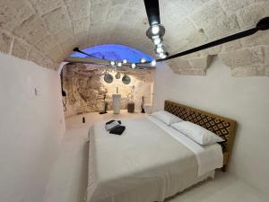 a bedroom with a large bed in a room with a stone wall at LEFKÓ OSTUNI, JACUZZI VISTA Mare in Ostuni