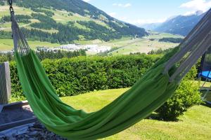 a green hammock with a view of a mountain at Hattlerhof in Heinfels