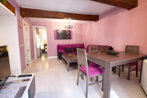 a living room with a wooden table and pink walls at El Balcón del Salvador in Cuenca