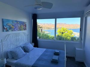 a bedroom with a bed and a large window at Mirador del Mar in Puerto de Mazarrón
