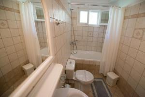 ein Badezimmer mit einem WC, einer Badewanne und einem Waschbecken in der Unterkunft Sofia Hotel in Nikiana