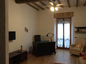 sala de estar con TV, sofá y ventana en Ca' Lina en Lainate