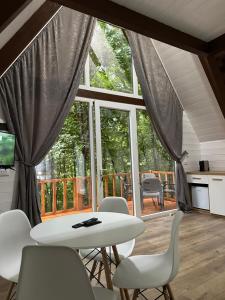 a room with a table and chairs and a balcony at Forest Escape in Theth