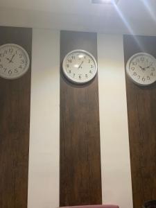 three clocks on the wall in a room at Golden Sand Pyramids in Cairo