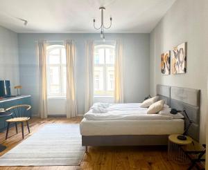 a bedroom with a large bed and two windows at Apartamenty Śródmiejska in Świebodzin