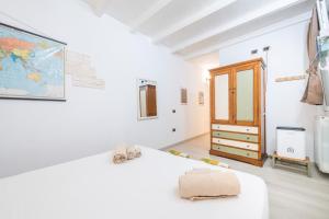 a white room with a bed and a dresser at St John Apartment in Cagliari