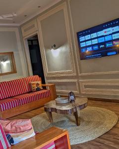 ein Wohnzimmer mit einem roten Sofa und einem Tisch in der Unterkunft Karibu Cottage Safari in Nkunjila