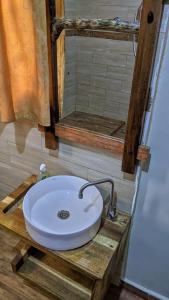 ein weißes Waschbecken auf einer Holzplattform in einem Badezimmer in der Unterkunft Karibu Cottage Safari in Nkunjila + 32 Fotos