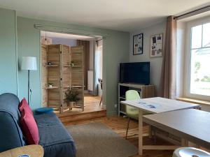 a living room with a blue couch and a table at Gîte PREY DES VOSGES in Prey