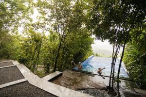a group of people in the water at a swimming pool at Manarala Villa in Pahala Neboda