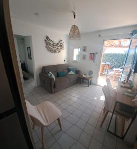 a living room with a couch and a table at 5 min du village de Noël Barcarès mas de pêcheurs 8 couchages tout confort in Le Barcarès