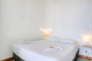 a white bed in a room with two towels on it at Mosala 1 - studio pieds dans l'eau - Saint-Leu in Saint-Leu