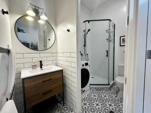 a bathroom with a sink and a shower with a mirror at Skytower views, Wi-Fi, washer & dryer!! in Auckland +10 photos