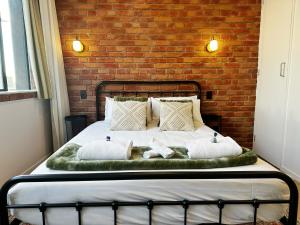 a bedroom with a bed with a brick wall at Skytower views, Wi-Fi, washer & dryer!! in Auckland