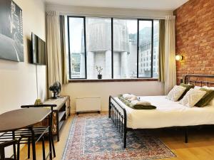 a bedroom with a bed and a table and a window at Skytower views, Wi-Fi, washer & dryer!! in Auckland