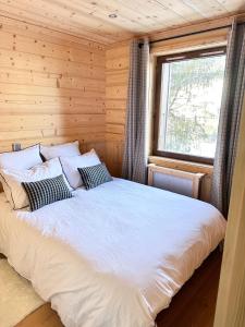een slaapkamer met een groot wit bed met een raam bij Megève Rochebrune, superbe appartement avec jardin in Megève