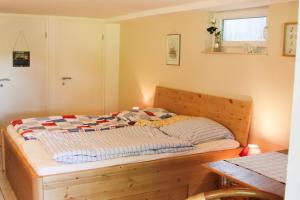 a bed with a wooden frame in a room at FeWo Seelücke in Munkbrarup