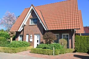 une maison en briques avec un toit orange dans l'établissement Dirks Ferienhaus Arngast, à Dangast