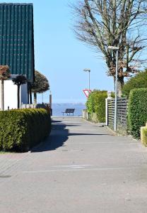 un trottoir avec banc et océan en arrière-plan dans l'établissement Dirks Ferienhaus Arngast, à Dangast