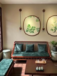 a living room with a green couch and two mirrors at Ngải Spa, Body, Foot Massage in Hanoi
