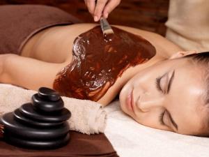 a woman laying on a bed with a bottle of bbq sauce at Massage studio-spa in Ginsheim-Gustavsburg