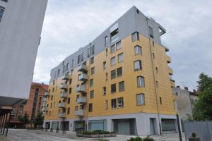 un edificio amarillo y gris en una calle de la ciudad en Central Apartment Anita Tour As Ljubljana, en Liubliana