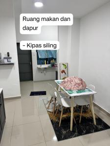 a dining room with a table and chairs in a room at AzureGreen at AmanPlus Kuantan in Kuantan