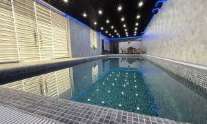 ein Hallenbad mit großem Schwimmbecken in der Unterkunft Mubina East Hotel in Buxoro