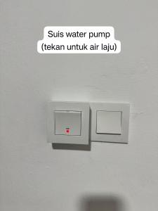 a lightswitch on a wall with a text bubble sayingsuits water at AzureGreen at AmanPlus Kuantan in Kuantan