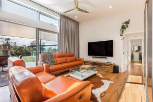 a living room with orange furniture and a flat screen tv at Woodbridge Vista - Heated Pool in Yallingup in Yallingup Siding