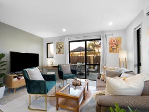a living room with a couch and chairs and a television at Apartment on Short ! in Christchurch