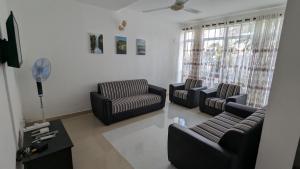 a living room with three couches and a table at Villa 19 Zone 2 Millennium City - Jaela in Ja-Ela
