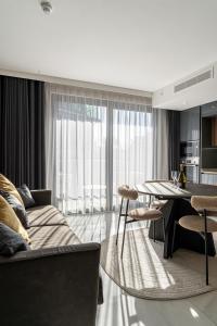 a living room with a couch and a table with chairs at Mercury Suite Designer Apartment with Pool Access in St. Julianʼs