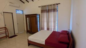 a bedroom with a bed and a chair and a window at Villa 19 Zone 2 Millennium City - Jaela in Ja-Ela